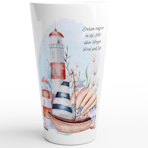May include: A white ceramic mug with a watercolor illustration of a lighthouse, sailboat, and seashells. The text "Einsam ragt er in die Höh, aber wegen Wind und See" is printed on the mug.