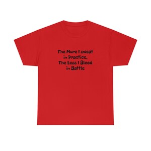 Może przedstawiać: Czerwony T-shirt z krótkim rękawem z czarnym tekstem, który brzmi "The More I sweat in Practice, The Less I Bleed in Battle."