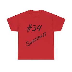 May include: Red t-shirt with black text that says "#34 Sweetness"