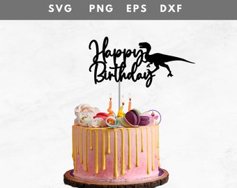 May include: A pink birthday cake with gold drips, topped with a black "Happy Birthday" cake topper featuring a dinosaur silhouette. The cake is decorated with macarons, flowers, and lit candles. The cake sits on a wooden base.