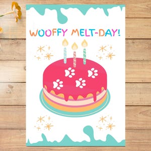 May include: A greeting card with a pink cake decorated with white paw prints and three candles. The text "WOOFFY MELT-DAY!" is written above the cake in colorful letters. The card has a white background with blue accents.