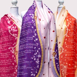 May include: Three silk scarves with a floral pattern and text in a gold oval. The text on the scarves reads "She also provides food for her household...", "She is not afraid of the snow for all her household...", and "Her husband is known in the gates..."