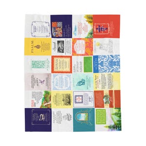 May include: A white throw blanket featuring a patchwork design with various colorful squares. Each square contains text and illustrations, with themes of faith and scripture. The blanket is a decorative home textile.