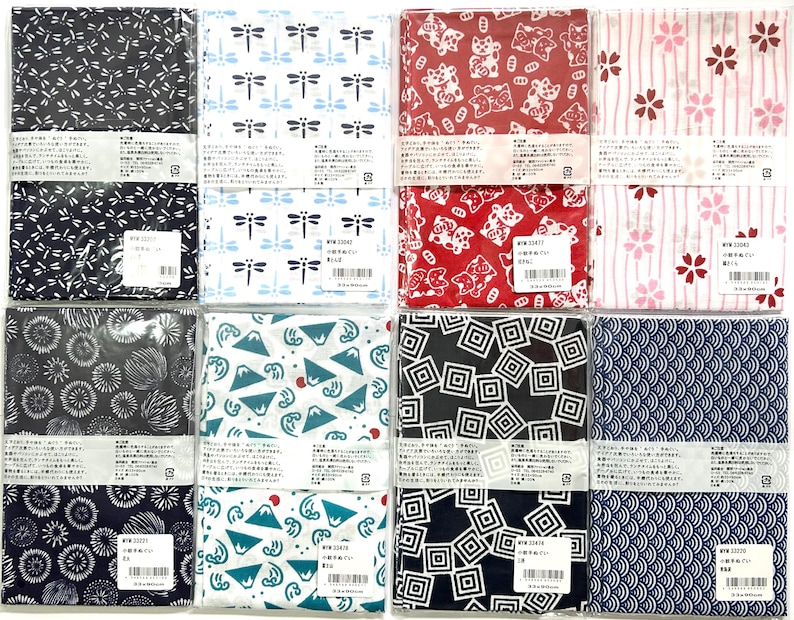 May include: Eight rectangular fabric cloths packaged in clear plastic, each featuring distinct Japanese-inspired patterns including dragonflies, maneki-neko cats, cherry blossoms, fireworks, mountains, geometric squares, and wave motifs.
