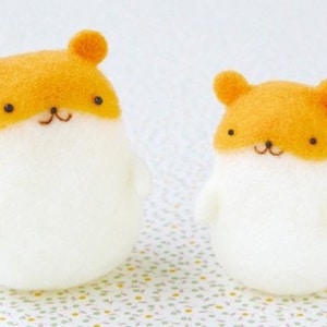 Könnte beinhalten: Zwei Filz-Hamster-Plüschtiere, eines größer als das andere. Beide sind weiß mit orangefarbenen Köpfen und schwarzen Augen.