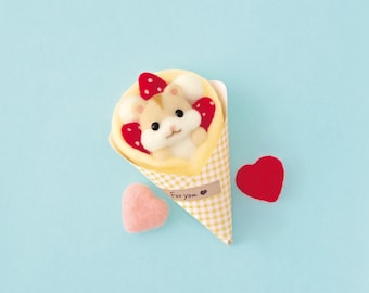 May include: A felted hamster figurine nestled inside a yellow and white gingham paper cone, topped with red strawberry shapes. The cone features a small brown label with the text For you and a heart icon, accompanied by two felt hearts.