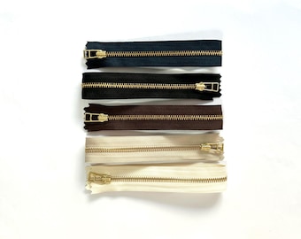 Cremalleras YKK de 30 cm, cursor y dientes color oro metalizado.
