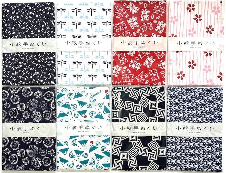 May include: Eight rectangular fabric cloths with various patterns including dragonflies, cats, cherry blossoms, fireworks, mountains, waves, and geometric shapes. Each cloth features a white paper band with the Japanese text 小紋手ぬぐい and MADE IN JAPAN.