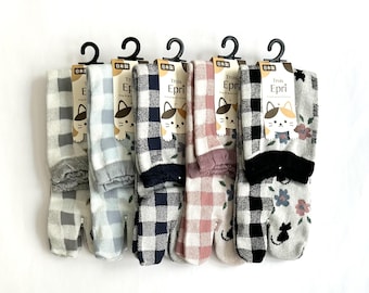 May include: Five pairs of split-toe socks hanging on black plastic hooks. Each pair features a different color gingham check pattern, including gray, light blue, navy, pink, and black. The packaging displays the text Trois Epri and a cat icon.