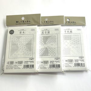 Può includere: Tre kit Sashiko Sampler con diversi motivi geometrici bianchi su sfondo bianco. Le confezioni con etichetta giapponese misurano 34 cm x 34 cm. Kit per l'artigianato tradizionale giapponese Sashiko.