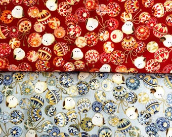 May include: Two pieces of fabric featuring a repeating pattern of small white birds and decorative spherical ornaments. The top fabric is red, while the bottom fabric is light blue. Each ornament displays intricate geometric and floral designs.
