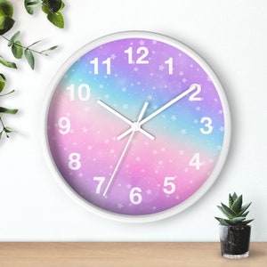 May include: A white clock with a pink, purple, and blue ombre background. The clock face has white numbers and a white star pattern. The clock hands are white.
