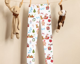 May include: White leggings featuring a repeating Christmas-themed pattern of gingerbread people, Santa Claus in a sleigh, penguins, snowmen, green pine trees, red gift boxes, candy canes, blue snowflakes, poinsettias, and mugs of hot cocoa.