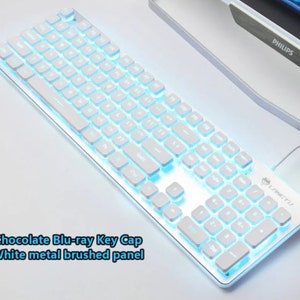 May include: White keyboard with blue backlit keys. The keyboard has a brushed metal panel and the text "L-FORCE771" is printed on the top right corner.