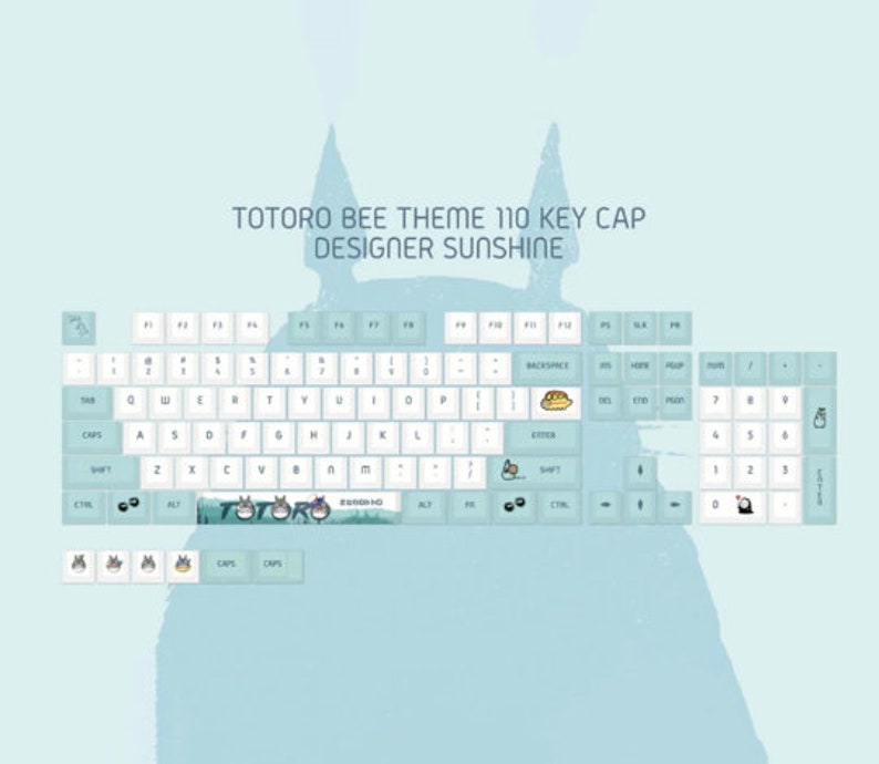 May include: A 110-key keyboard with a Totoro Bee theme. The keyboard has a light blue background with white keys and a variety of keycaps featuring Totoro characters. The keyboard also has a light blue and green keycap with the word "Totoro" printed on it.