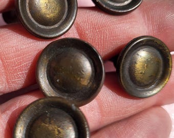 5 puxadores de armário em latão com formato de alvo e acabamento escuro, topo abaulado.