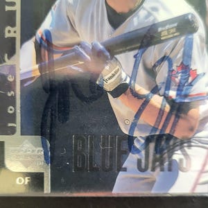 May include: A baseball card featuring a player in a Blue Jays uniform holding a bat. The card has the text "Blue Jays" and "Upper Deck" visible. The player's name "Jose Cruz" is also visible.