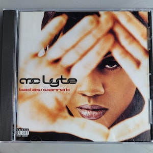 May include: CD case featuring the album "bad as I wanna b" by MC Lyte. The album cover has a sepia-toned image of a person's face framed by hands. The artist's name is in black, and the album title is in red.