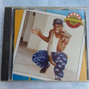 May include: A CD case featuring the album cover for "Cobra Bad Boy Talk." The cover art shows a man wearing a hat and blue jeans, with a snake around his neck. The album title is in a banner.