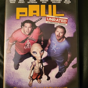 Puede incluir: Carátula de DVD para la película "Paul" con Seth Rogen, Simon Pegg, Jason Bateman y Kristen Wiig. La portada presenta una gran imagen de un extraterrestre con el texto "Incluye versiones sin censura y versiones teatrales".