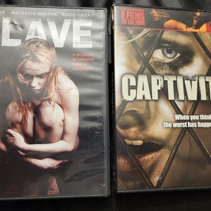 May include: Two DVD movie cases. The left case is for "Slave" with Sam Page and Natassia Malthe. The right case is for "Captivity" with the text "8 Films to Die For!" and "When you think the worst has happened..."