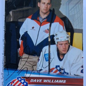 May include: A 2001 Choice trading card featuring Dave Williams, Equipment Manager, in a red, white, and blue jacket. A hockey player in a white jersey and helmet is in the foreground. The card includes the text "DAVE WILLIAMS" and "EQUIPMENT MANAGER".