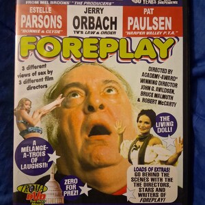 May include: A DVD case for the film Foreplay, featuring a large portrait of Zero Mostel with an open-mouthed expression. The cover includes text listing actors Estelle Parsons, Jerry Orbach, and Pat Paulsen, along with promotional blurbs and the Troma logo.
