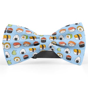 May include: A blue bow tie with a pattern of cartoon sushi rolls and other Japanese food items.