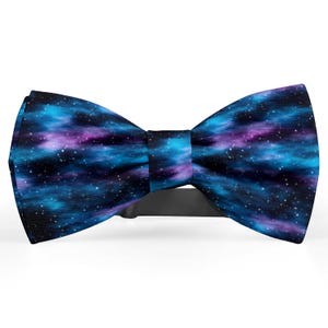 May include: A bow tie with a vibrant galaxy design. The bow tie features a black band and a pattern of blue, purple, and white, resembling stars and nebulae. This accessory is suitable for formal events or adding a unique touch to an outfit.
