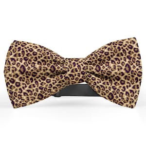 May include: A brown and black bow tie with a leopard print pattern.