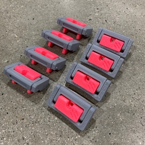 May include: Eight gray plastic drawer pulls with a pink insert. The pulls have a rectangular shape with rounded corners.