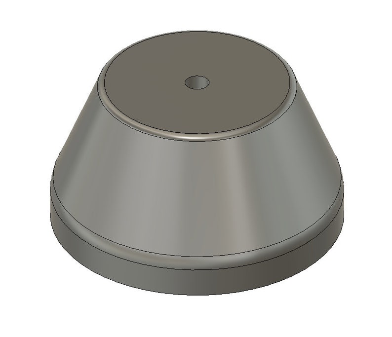 May include: A gray, round, pedestal with a small hole in the center. The pedestal is made of a smooth, hard material and has a slightly flared base.