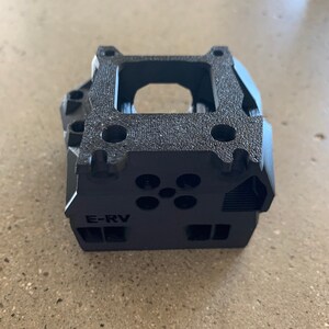 May include: Black plastic carburetor spacer with the text "E-RV" printed on the side.