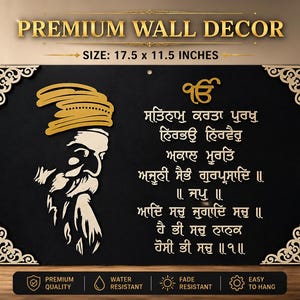 May include: A rectangular black wall decor sign measuring 17.5 by 11.5 inches. It features a gold-coloured profile of a bearded figure wearing a turban on the left and Gurmukhi script on the right. The corners have decorative gold filigree accents.