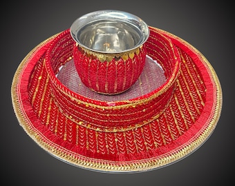 May include: A red and gold decorative tray with a silver bowl in the center. The tray is decorated with sequins and fringe.
