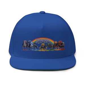 Peut inclure: Une casquette snapback bleu roi avec une impression graphique de personnages fondants colorés sous un arc-en-ciel. Le texte "TAKANAKA" et "Rainbow Goblins" est imprimé dans une police stylisée au-dessus des personnages alignés sur le devant.