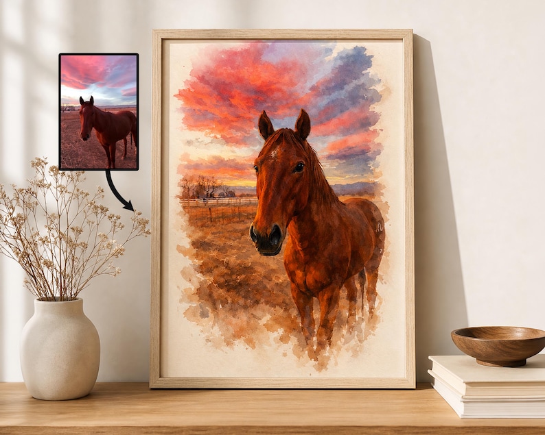 Puede incluir: Pintura a la acuarela de un caballo marr&oacute;n de pie en un campo bajo una vibrante puesta de sol. La obra de arte est&aacute; enmarcada en un marco de madera clara. El cielo est&aacute; lleno de tonos de rojo, naranja y morado.