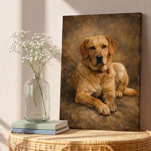 Może przedstawiać: Wydruk na pł&oacute;tnie przedstawiający złotego psa rasy Labrador Retriever. Pies leży z czerwoną obrożą na brązowym i beżowym tle. Grafika jest wystawiona na stole z wazonem białych kwiat&oacute;w i książkami.