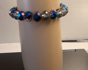 May include: A bracelet made of iridescent blue and clear faceted glass beads.