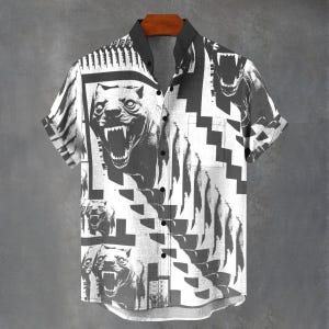 May include: Short-sleeved shirt with a black and white graphic design. The shirt features a repeating pattern of a snarling dog's face, geometric shapes, and vertical lines. The collar and buttons are black.