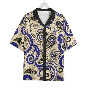 May include: Short-sleeved button-down shirt with a cream-colored background and a paisley pattern in black and blue. The shirt has a black collar and a V-neck design.