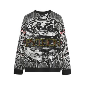 May include: A long-sleeve sweatshirt featuring a black and white snakeskin pattern throughout. The centre displays a large, circular graphic of a coiled python with the word PYTHON printed in yellow and red lettering across the snake's body.