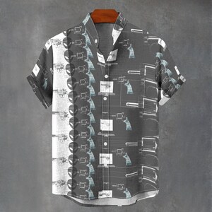 Könnte beinhalten: Ein kurzärmeliges Hemd mit Knöpfen und einem schwarz-weißen Muster aus stilisierten Revolvern. Das Hemd hat einen dunkelgrauen Hintergrund mit einem weißen Muster auf der linken Seite und einem schwarzen Muster auf der rechten Seite.