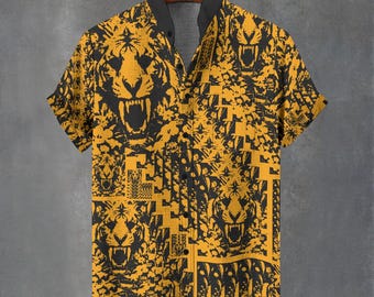 May include: Yellow and black short-sleeve button-down shirt with a tiger face pattern. The shirt has a black collar and is hanging on a wooden hanger. The tiger face design is repeated across the shirt.