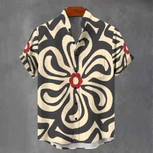 May include: A short-sleeved button-up shirt with a black and cream abstract floral pattern. The flower has a red centre.