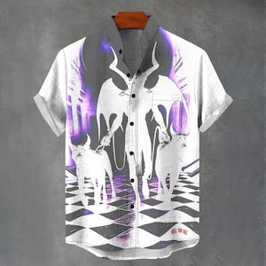 Könnte beinhalten: Weißes Button-Down-Hemd mit einem grafischen Design, das eine gehörnte Figur mit Flügeln, zwei gehörnte Kreaturen und ein Schachbrettmuster zeigt. Das Design enthält lila und graue Farbtöne. Das Hemd hat kurze Ärmel und einen Kragen.