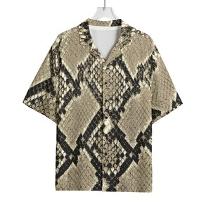 May include: Short-sleeved button-down shirt featuring a snake skin pattern in tan, black, and white. The shirt has a classic collar and a relaxed fit. The snake skin design is printed across the entire shirt, offering a bold, eye-catching look.