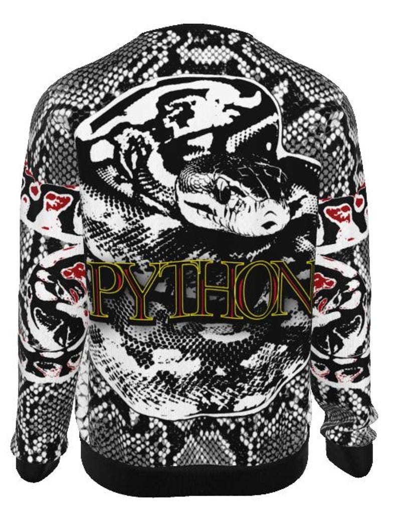 May include: A long-sleeve sweatshirt featuring a black and white snakeskin pattern throughout. The centre displays a large graphic of a coiled snake with the word PYTHON printed in yellow letters with a red outline across the snake's body.