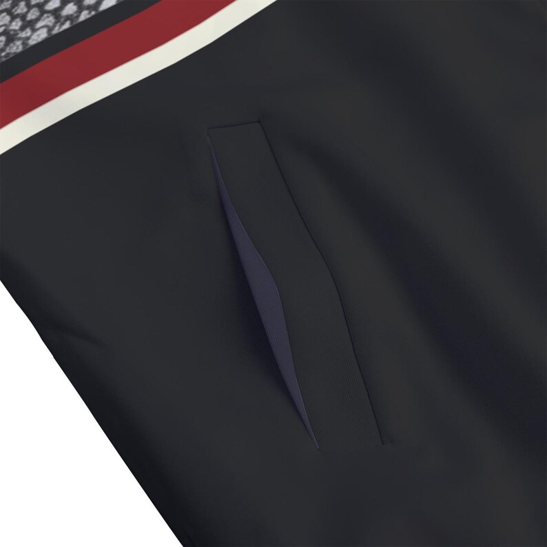 May include: A solid black jacket featuring a vertical slit pocket on the front. The upper portion of the garment displays a horizontal stripe pattern in deep red and white, positioned above a section with a small, repeating grey floral print.