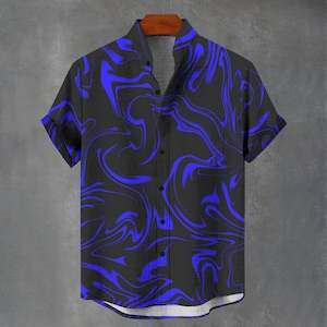 May include: Short-sleeved shirt with a black base and a striking blue, swirling design. The shirt is displayed on a wooden hanger against a grey wall. It features a classic collar and a button-up front.